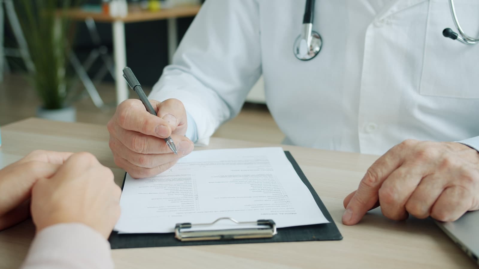A doctor writing notes on a patient's chart